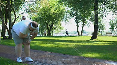 Fat man feels heart attack while running, obese girl helping him, friend support