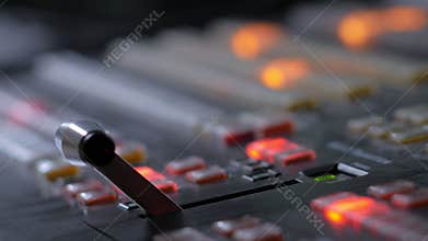 Television director is moving handle on a control panel during tv filming in studio