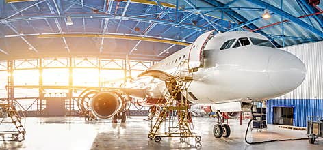 Maintenance and repair of aircraft in the aviation hangar of the airport, view of a wide panorama