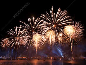 Gorgeous multi-colored light show and fireworks display on dark night sky over the river Daugava