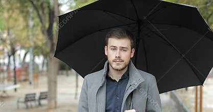 Angry man complaining in a rainy day looking at you