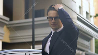 Confident business man in suit reaches destination place, checking time on clock