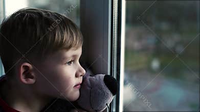 Sad Little Boy Lonely Child With Bear Near Looking Through Window The Little Boy