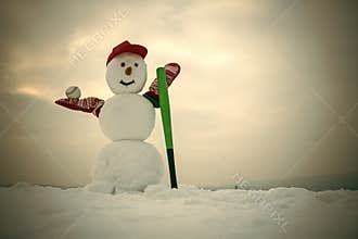 Christmas snowman in cap with baseball bat in winter