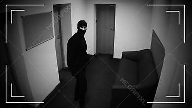 Dangerous criminal in balaclava showing middle finger at surveillance camera