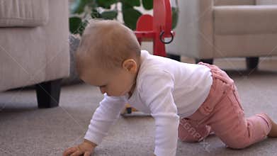 Baby girl crawling in living room