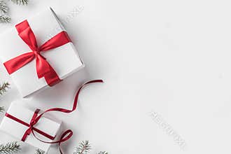Christmas gift boxes with red ribbon on white background with Fir branches.