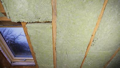 Man installing thermal roof insulation layer - using mineral woo