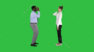 Young woman and young man in formal clothes give high five on a Green Screen, Chroma Key.