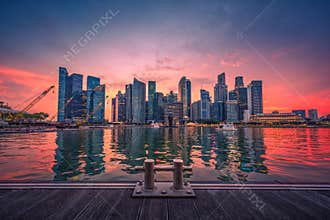 Singapore Skyline and view of business district downtown with wooden walkway on Marina Bay at sunset.