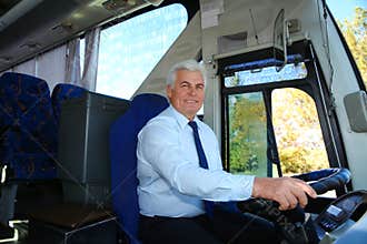 Professional bus driver at steering wheel.