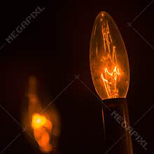 Orange glow of incandescent light bulb on low power in home