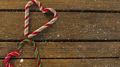 Falling snow with Christmas hearts decoration on wood