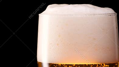 Light beer pouring in glass. With bubbles and foam.