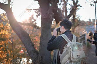 Backpack man taking pictures in autumn season