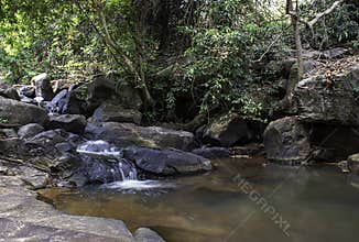 The water flowing over rocks and trees down a waterfall at Khao Ito waterfall , Prachin Buri in Thailand