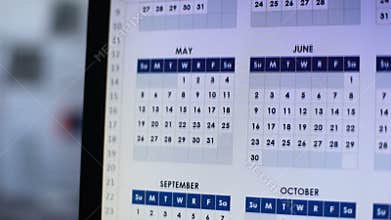 Person looking through calendar on pc, planning annual lending, installment