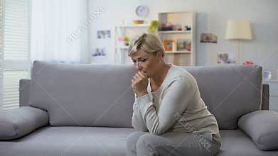 Depressed aged woman sitting alone at home, difficult time, breakup sorrow