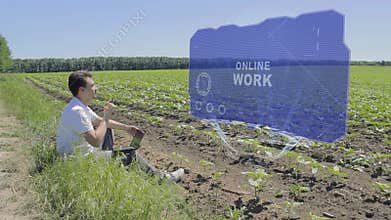 Man is working on HUD holographic display with text Online work on the edge of the field