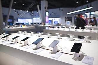 Showcase with smartphones in the modern electronics store. Many smartphones on the shelf of the technology store