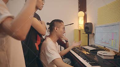 Young asian musicians working together editing music