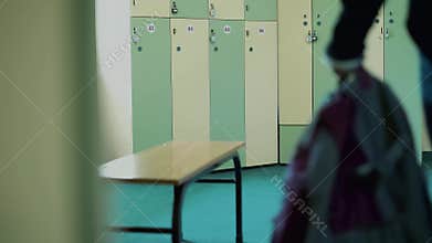 Young girl-athlete in the locker room of the gym, unbuttoned, sweatshirt