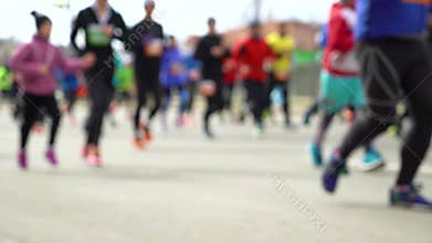 Blurred colorful crowd of people running at city marathon on asphalt road