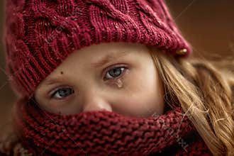 Sad little girl portrait with accent on eyes with tear