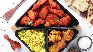 Spicy indian fried chicken served with curry vegetable rice, onion bhajia, naan bread