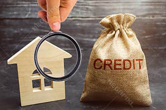 A bag with money and the word Credit near the house. Buying a property in debt. Loan for housing. Mortgage loan to buy an