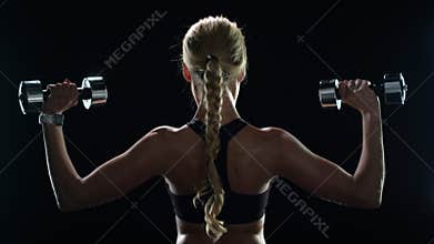 Sport woman training with dumbbells in slow motion. Fitness girl exercising