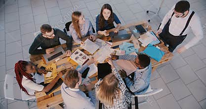 Top view business people group work together on meeting with male boss and female expert coach in modern light office.