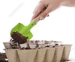Hands Using Shovel Placing Soil into Compost Pots