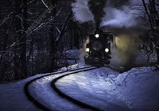 Budapest, Hungary - Beautiful winter forest scene with snow and old steam locomotive on the track in the Hungarian woods