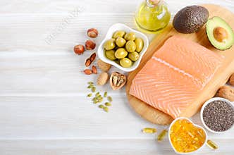 Selection of healthy unsaturated fats, omega 3 - fish, avocado, olives, nuts and seeds.