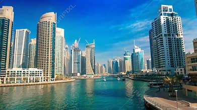 Dubai Marina under blue sky, with boats and skyline