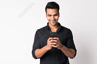 Portrait of young happy Indian businessman using phone