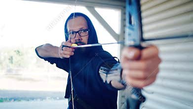 Man archer is shooting from sports bow