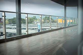 Long corridor with hardwood floor and car park background