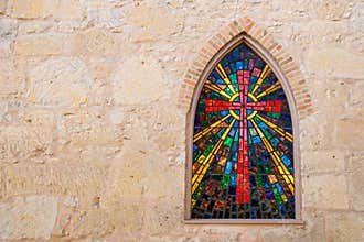 Gothic style church window with stained glass/ red cross made of stained glass
