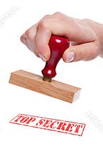 Hand holding a rubber stamp with the words Top Sec
