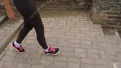 Close Up Of Athletic Female Legs Jogging Down The Stairs