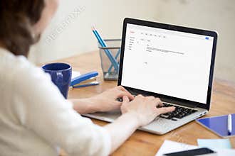 Business lady in office typing reply to corporate email.
