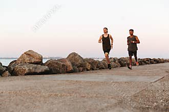 Two young fitness men running outdoors