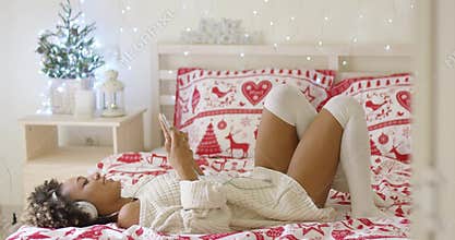 Woman laying down and listening to digital device