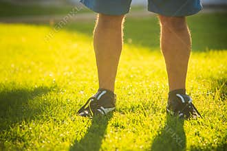 Legs of Man on Sunny Green Grass Lawn