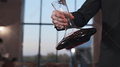 Barman shakes the wine in a decanter in slow motion, 240 frames per second, alcohol drinks, wine in restaurant