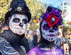SAN ANTONIO, TEXAS - OCTOBER 28, 2017 - Couple wears face paint and hats decorated with flowers and skulls for Dia de los Muertos/