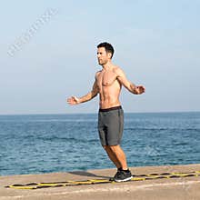 Training on agility ladder by the sea