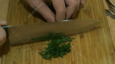 Male hands slicing dill. Russian cuisine.